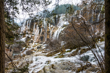 Fototapeta na wymiar Waterfall from a cliff in the forest