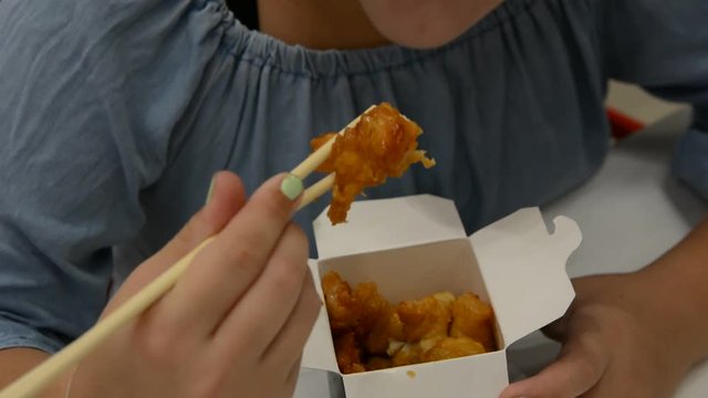 cute girl eats asian fried chicken. delicious fried chicken pieces. close up sof
