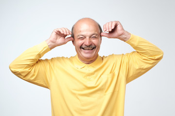 Mature adult man with moustache laughing looking at the camera over white background. Some jokes...