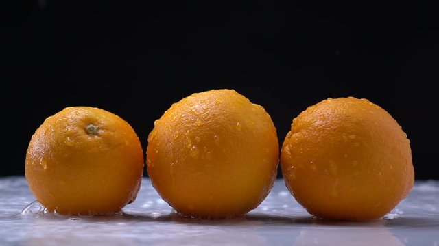 water splashing on an orange fruit in slow motion.