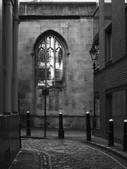 Obraz na płótnie Canvas Black and white image of an atmospheric alley with cobblestone..