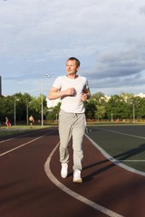 a healthy lifestyle - a sports man of European appearance runs around the stadium