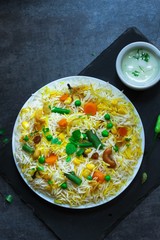 Homemade Vegetable Biryani / Veg Pilaf or Pulao on dark background top view