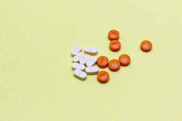 White pills on yellow background