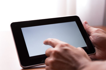 Young adult caucasian male holding a digital tablet horizontally indoor