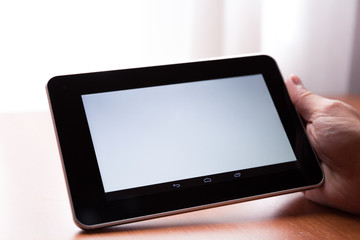 Young adult caucasian male holding a digital tablet horizontally indoor
