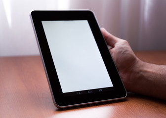 Young adult caucasian male holding a digital tablet vertically indoor