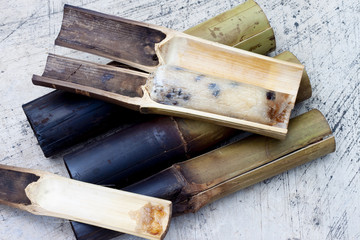 Fototapeta na wymiar Glutinous rice roasted in bamboo joints put on cement floor.