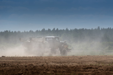 Military or army tank ready to attack and moving over a deserted battle field terrain. a lot of dust.