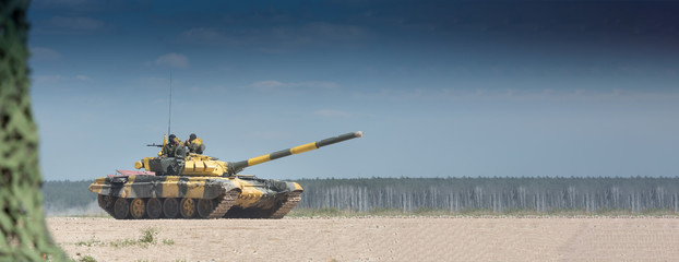Military or army tank ready to attack and moving over a deserted battle field terrain. a lot of...