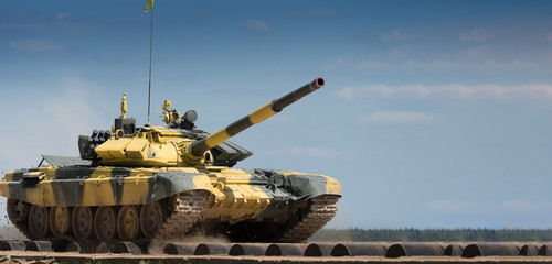Military or army tank ready to attack and moving over a deserted battle field terrain. a lot of...
