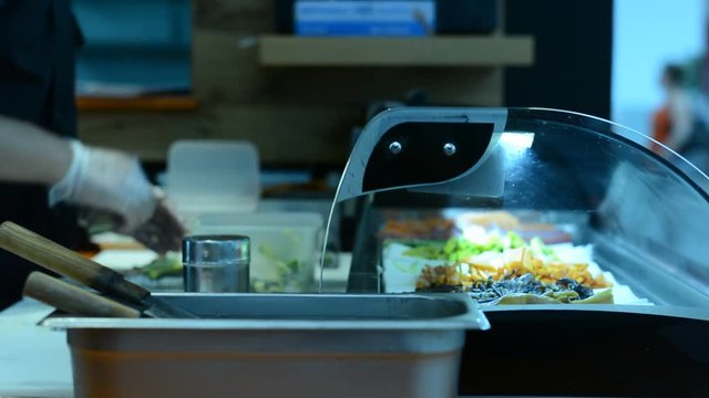 Sushi Chef Slices fresh Salmon and other ingredients