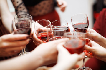 Clinking glasses of red wine in hands