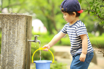 バケツに水を汲む男の子