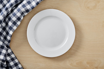 textile cell napkin on wooden table with copy space and white empty plate