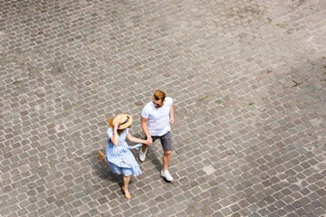 high angle view of woman in straw hat walking with redhead boyfriend at city street