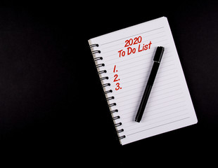 To Do List year 2020, Black Pen and a Notebook, Red text, list 1,2,3. isolated on black background, new year resolution and plans concept