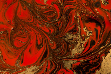 Gold marbling texture design. Red and golden marble pattern. Fluid art.
