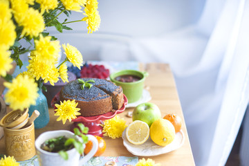 Fresh tea with mint and lemon on a table with yellow flowers. Delicious homemade breakfast. Place for text