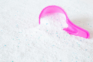 Pink cup or scoop of white powder. Detergent for clothes washing. Dry cleaning concept. Chores of housewife. Regular washing. Empty place for text or logo.