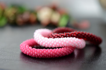 Set of three beaded children's bracelets on a dark background close up