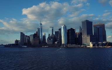 New York City skyline with urban skyscrapers over Hudson River. Manhattan downtown panorama. Waterfront view to the harbor at sunset.

