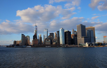New York City skyline with urban skyscrapers over Hudson River. Manhattan downtown panorama. Waterfront view to the harbor at sunset.