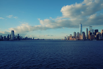 Naklejka premium New York City skyline with urban skyscrapers over Hudson River. Manhattan downtown panorama. Waterfront view to the harbor at sunset.