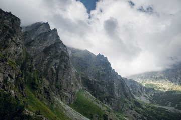 Obraz na płótnie Canvas Scenic view of sharp rocky mountain peaks in the dark clouds near the Morskie Oko lake, High Tatras, Zakopane, Poland. Foggy day
