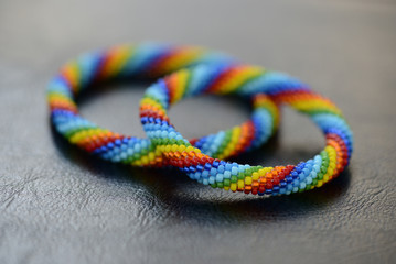 Set of rainbow bracelets for mother and daughter on a dark background close up