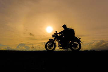 Motorcycle or motorbike Silhouette with Traveler male rider standing at the river.