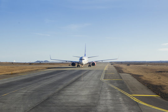 White passanger plane on runway air strip while takeing off take off in iceland keflavik northern country clear sky