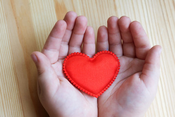 red fabric heart in children's palms