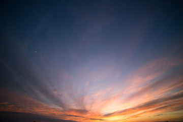 Obraz premium Dramatic Partially Cloudy and Crimson Sunset Sky with Moon Crescent