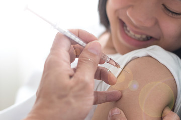 Vaccine HPV healthcare concept. Image of healthy Asia young adult kid girl getting vaccination with doctor pediatrician's hand holding medical syringe in hospital.