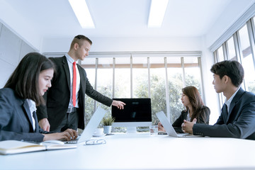 Business team during meeting conference are working documents about the marketing plan and finance sales report of the company with laptop computer and smartphone tablet on work table