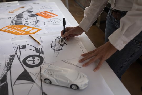 Businesswoman drawing car sketch in office