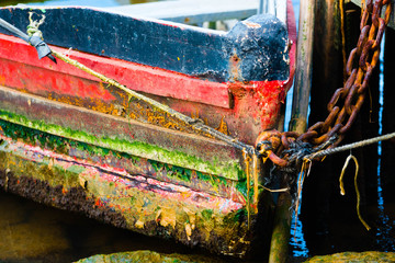 Close-up of the bow of a fishing boat chained to the berth