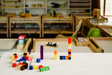 Montessori material, game to learn addition, made in colorful plastic blocks, inside a Montessori classroom.
