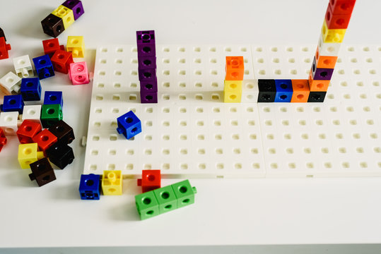 Montessori material, game to learn addition, made in colorful plastic blocks, inside a Montessori classroom.