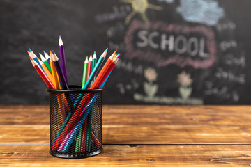 colored pencils on wooden background with chalkboard school - 217347803