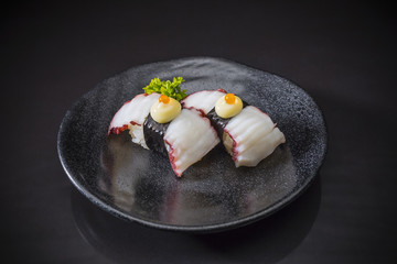 Tako Nigiri, Sushi tako served on traditional Japanese food on ceramic dish, Japanese food style, Japanese menu, Tako sushi, Sushi Nigiri, Tako, Octopus on black background, selective focus