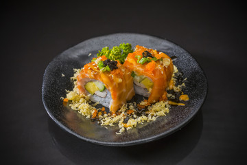 Salmon Sushi-Roll with  sauce and Tempura, Japanese food on ceramic dish, Japanese food style, Sushi Menu, salmon sushi roll on black background, selective focus