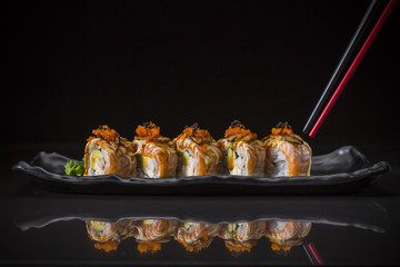 Aburi, Salmon Roll topped Foie Gras Roll served on long dish, Japanese food style, Sushi Menu, salmon sushi roll on black background, selective focus