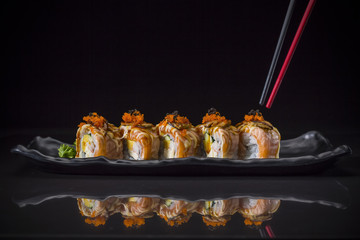 Aburi, Salmon Roll topped Foie Gras Roll served on long dish, Japanese food style, Sushi Menu, salmon sushi roll on black background, selective focus