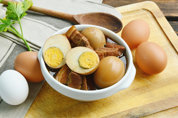 Eggs Stewed or Thai name is khai phalo muu saam chan on wooden background.