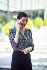 Fototapeta premium Businesswoman walk in city financial district and talking on phone