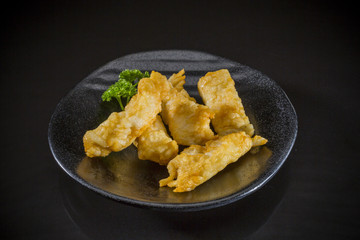 Naklejka na ściany i meble Asian food, fried fish tofu on black background, Traditional Japanese food, Sukiyaki Menu