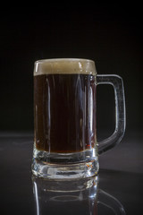 Pint glass of black beer, Glass of dark beer on black background, Beer glass with dark cold beer, Mug of frosty dark stout with bubble foam  froth