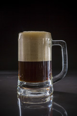 Mug of black beer, Glass of dark beer on black background, Beer glass with dark cold beer, Pint glass with dark stout with bubble froth